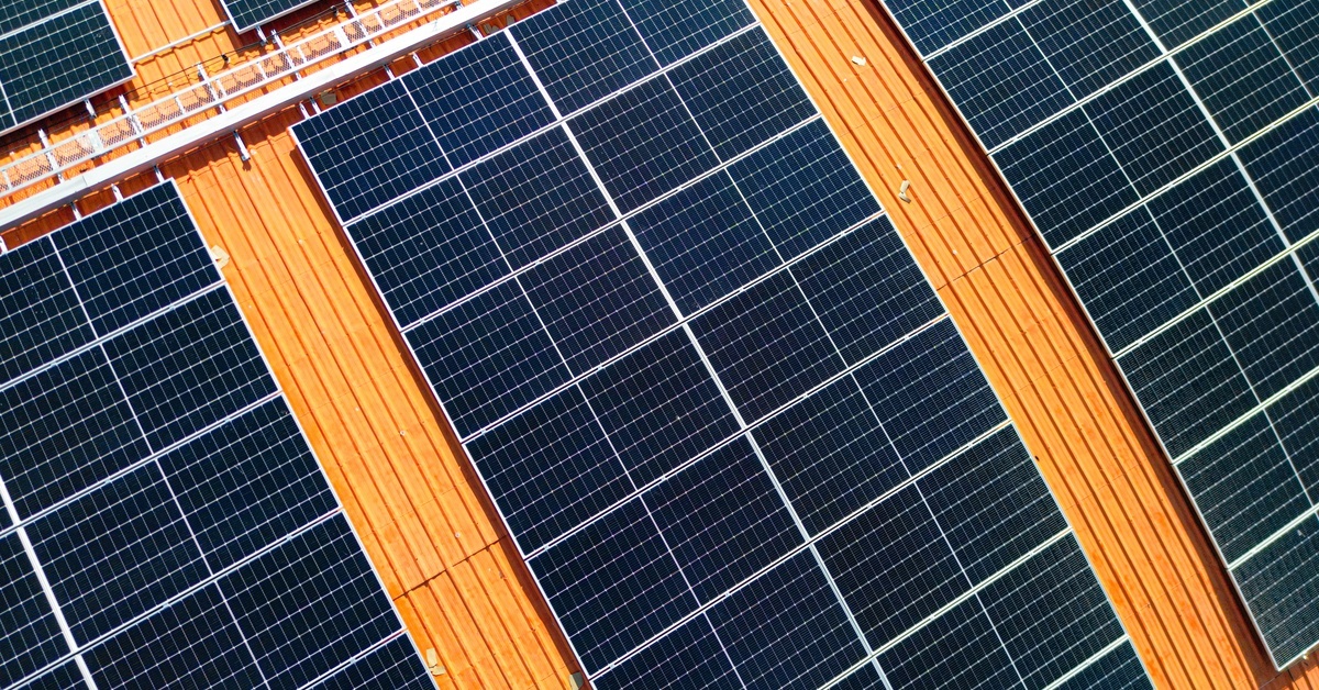 A commercial solar grid installed onto the curved roof of a building. They are separated into sections.