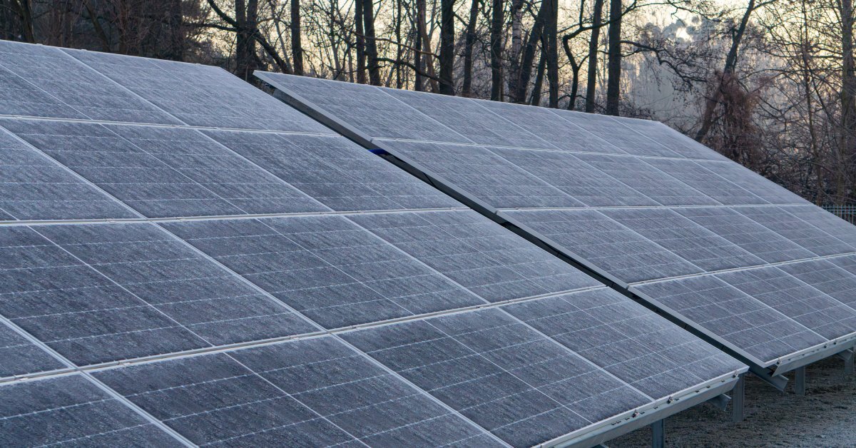 Two large solar panels mounted at an angle outside. There is a layer of frost on the surface of the panels.